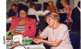 Driver safety classes, such as AARP's recently updated Driver Safety Program, can help older adults learn about age-related changes that can affect their driving and about ways to remain safe behind the wheel. These women are reviewing course materials during one such class.