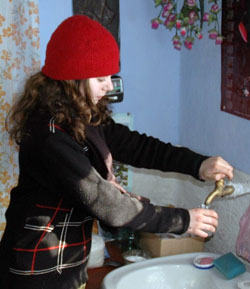 Photo of: Irina Cojocaru draws water from the tap in her house instead of walking kilometers to fill buckets.