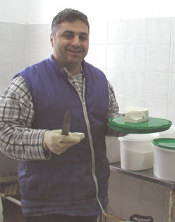 Rona Company co-owner Remzi Shahini exhibits his new feta cheese. Rona Company is one of four dairy processors in Kosovo making new dairy products thanks to USAID training in processing techniques.