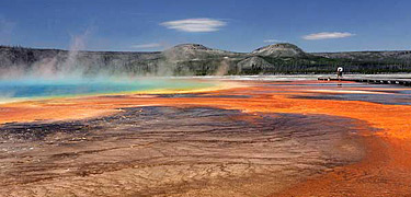 Steam rises above the beautiful browns, oranges, and blue colors of Grand Prismatic Spring.