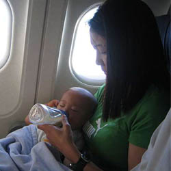 Mother bottle-feeding baby on airplane