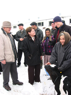 Farmer-to-Farmer Volunteer Norval Dvorak, left, and Peace Corps Volunteer Ben Tirrell, right, explain to US Ambassador Heather Hodges how they helped the Moldovan village of Dusmani revive its agriculture sector.