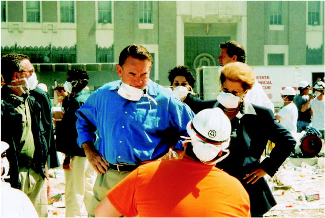 This photo shows the Health and Human Services Secretary Tommy Thompson and New York State Health Commissioner Dr. Antonia Novello speaking with rescue workers on September 13, 2001, at the site of the World Trade Center terrorist attacks in New York City.