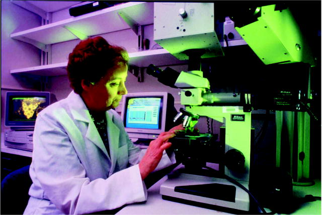 This is a photo of one of NIH's medical research scientists shown here adjusting a microscope.