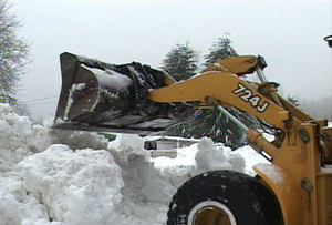 Photo:Crews pile snow beside the road.