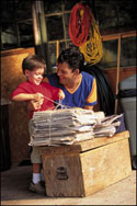 Photo: A father and son bundling newspapers