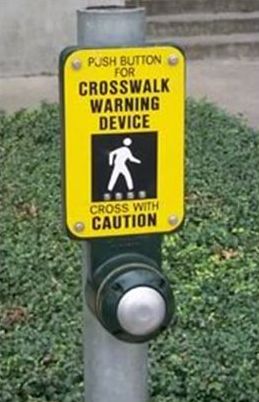 The picture on the left shows a close-up view of a pushbutton and supplemental plaque that says "PUSH BUTTON FOR CORSSWALK WARNING DEVICE – CROSS WITH CAUTION". 