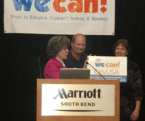 Image of Karen Donato presenting We Can City Sign to recipients in South Bend