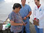 female responder shows info on handheld device to other medical personnel at exercise