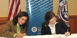 Staff Management representative Claudia Roemer and Assistant Secretary Julie L. Myers sign IMAGE Agreement.