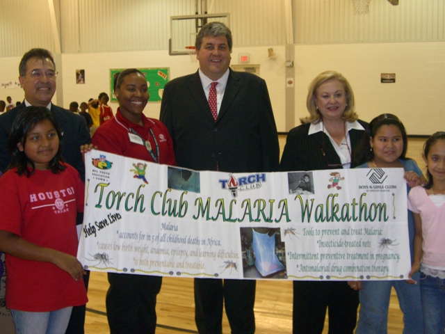 Photo - HHS Acting Deputy Secretary Eric Hargan with members of the Houston Boys and Girls Club holds a sign that reads "Torch Club MALARIA Walkathon!"