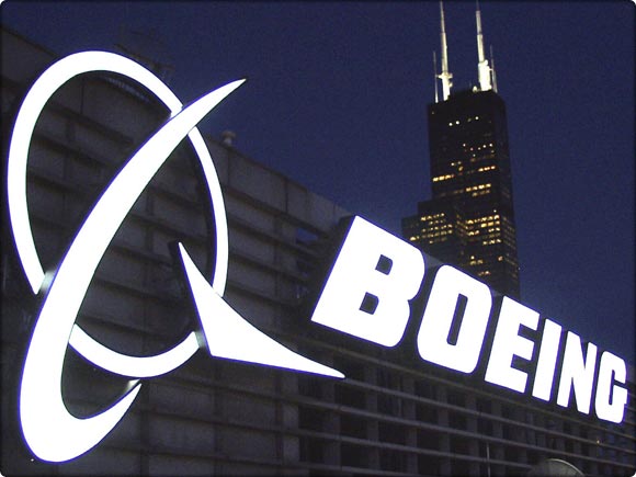 Boeing logo on top of 100 N. Riverside in Chicago with Sears Tower in background at night.