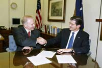 Washington Group International's Chief Operating Officer, Thomas H. Zarges, and OSHA's then-Assistant Secretary, John Henshaw, shake hands after signing the OSHA and Washington Group International renewal Alliance agreement