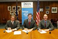 (Seated left to right) Bruce N. Scholnick, President and CEO, NWPCA , OSHA's then-Assistant Secretary of Labor, John Henshaw, and Dr. John Howard, Director, NIOSH, sign the OSHA/NWPCA/NIOSH Alliance.