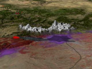 A view of the region around Denver, Colorado, on June 9, 2002, during the Hayman fire.  Both the reddish image and the 3D smoke plume are measurements from the MISR instrument on Terra.  The Hayman fire is located at the leftmost end of the smoke plume, represented in red from MODIS fire incidence data.  The regions in purple are regions of large population density, and Denver is right underneath the right end of the plume.