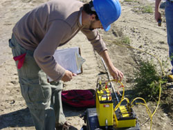  [Photo: USGS OGW, BG Scientist adjusts console during two-dimensional resistivity survey.] 