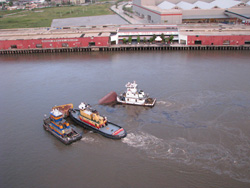 Tugs hold sections of the Barge DM932 as black oil continues to leak into the Mississippi River.