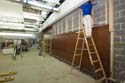 Carpenters install mahogany panels to a wall in the Food Service Area