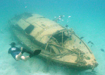 A diver examines a sunken sailboat in Guam.
