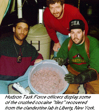 photo - Hudson Task Force officers display some of the crushed cocaine 'tiles' recovered from the clandestine lab in Liberty, New York.