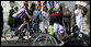 President George W. Bush reaches out to participants of the Wounded Warriors Soldier Ride as they cross in front of him during the kickoff Thursday of the White House to Lighthouse ride. White House photo by Chris Greenberg