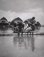 Margaret Mead on a canoe with Manus children