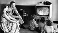 A U.S. serviceman watches television with his family