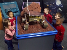 Visitors examine a model of a Mars Pathfinder.