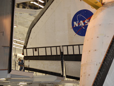 Space shuttle Endeavour is guided by technician.
