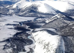 White Horse River East of YT110 showing snow melting into a river from nearby mountains