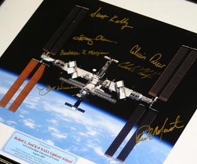 Crew signatures surround a picture of the space station