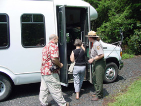 visitors boarding a park van that will enable them access to the historic home at the top of the hill.