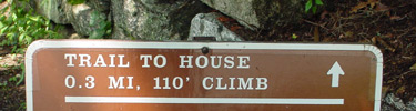 trail sign indicating a 110 foot elevation gain to the historic home