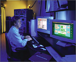 Researcher at computer terminal operating simulated module IV measurement system.