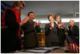 Laura Bush applauds as Secretary of Education Margaret Spellings and Afghan Minister of Education Noor Mohammas Qarqeen complete the signing of the Memorandum of Understanding for funds to build a university in Kabul, Afghanistan, Wednesday, March 30, 2005. 