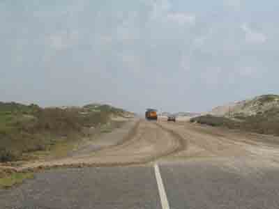 Image of SPI city maintenance workers clearing sand dunes from Highway 100