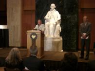 John Haynes addresses guests in Madison Hall as Carl Gershman looks on