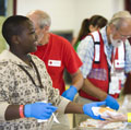 San Antonio, TX.  Raymond McGee, age 13, helps the Red Cross volunteers serve lunch at the shelter where he is staying.