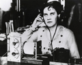 An employee of the National Bureau of Standards listens to a radio broadcast picked up by one of the first homemade crystal detector sets. 