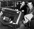 Newsman Walter Cronkite and two Commerce employees on computer panel