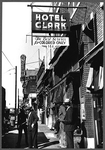 Secondhand clothing stores and pawn shop on Beale Street labeled with a sign: 'Hotel Clark, The Best Service for Colored Only.'