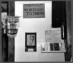 Signs behind the bar, including one that reads: 'Positively no beer sold to


     Indians.'