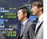 Japanese businessmen walk in front of share prices board in Tokyo, 18 Sep 2008