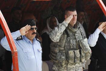 Gen. Jamal Tahir, the Kirkuk provincial police chief, and Col. David Paschal, commander, 1st Brigade Combat Team, 10th Mountain Division, render honors as the Iraqi national anthem is played prior to a Sons of Iraq contract signing ceremony held at the Bushariya Iraqi police station, 20 miles south of Kirkuk, on April 7. Gen. Jamal cited the successes of the SoI in helping to bring peace and stability to the neighboring Hawijah district which has recently seen a dramatic 70 percent drop in violent activities since standing up in December 2007. (U.S. Air Force photo/Staff Sgt. Samuel Bendet)