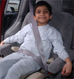 child properly restrained in a booster seat and seatbelt