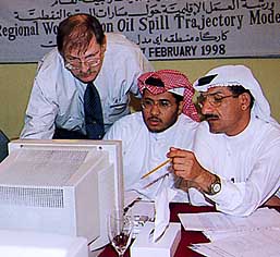 Three men looking at computer.