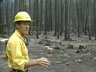 Jack Cohen in front of a burned line of trees near a home that was burned.