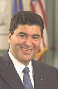 A close-up of Dr. Elias Zerhouni in front of the American flag at rest