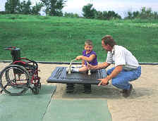 photo of a boy on a spring rocker that is equipped with a hand support