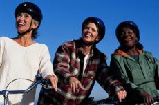 Fotografía de tres mujeres usando cascos de bicicleta
